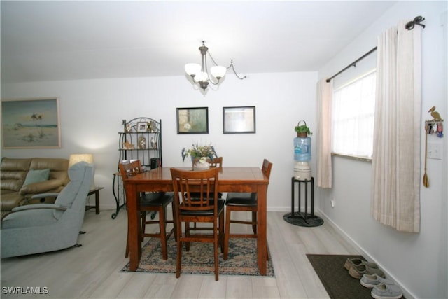 dining space featuring an inviting chandelier and light hardwood / wood-style flooring