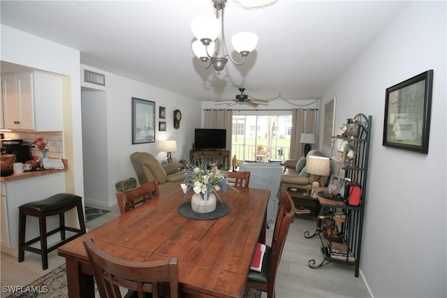 dining space featuring ceiling fan with notable chandelier