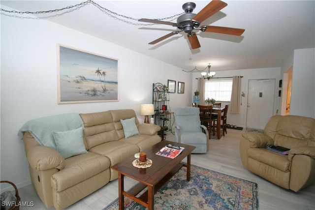 living room with ceiling fan with notable chandelier