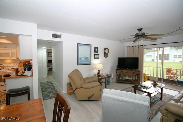 living room featuring ceiling fan and light wood-type flooring