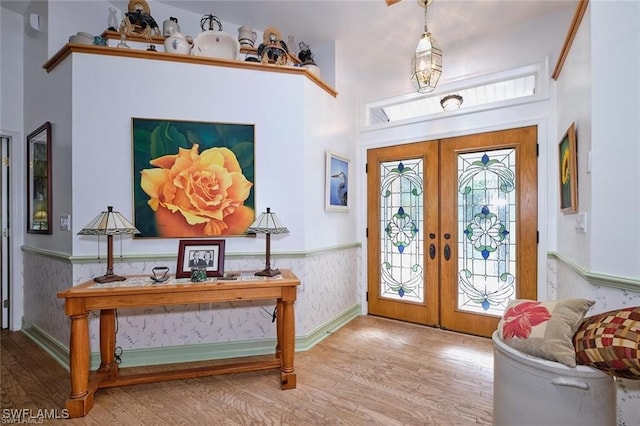 foyer with french doors and light hardwood / wood-style flooring