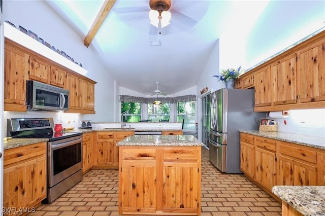 kitchen featuring light stone countertops, a center island, stainless steel appliances, and vaulted ceiling with beams