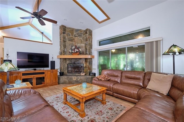 living room with hardwood / wood-style flooring, high vaulted ceiling, ceiling fan, and a fireplace