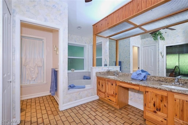 bathroom with ceiling fan, a bathtub, and vanity