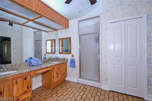 bathroom with ceiling fan, a shower with shower door, and vanity