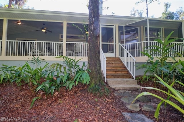 back of property with ceiling fan and a sunroom