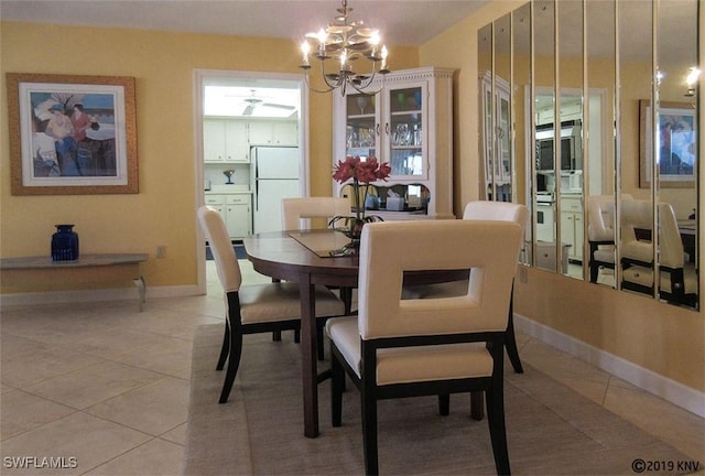 dining space featuring light tile patterned flooring and ceiling fan with notable chandelier