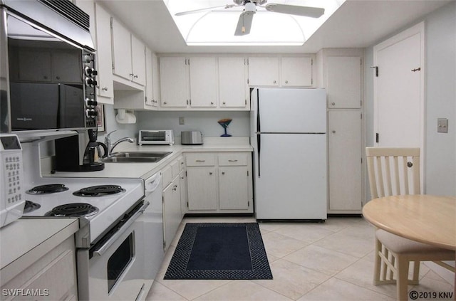 kitchen featuring sink, a skylight, light tile patterned floors, white appliances, and white cabinets