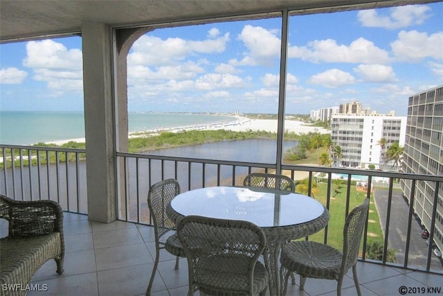 sunroom with a view of the beach and a water view