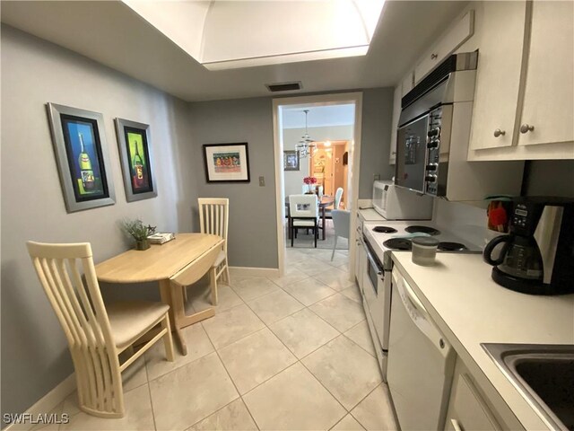 kitchen with white appliances, sink, and light tile patterned floors