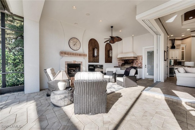 view of patio / terrace featuring an outdoor living space with a fireplace and ceiling fan