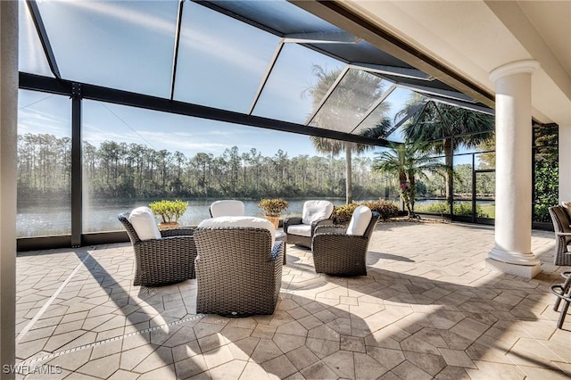 view of patio featuring a lanai and a water view