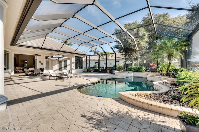 view of pool featuring a patio, ceiling fan, and glass enclosure