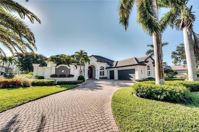 mediterranean / spanish house featuring a garage and a front yard