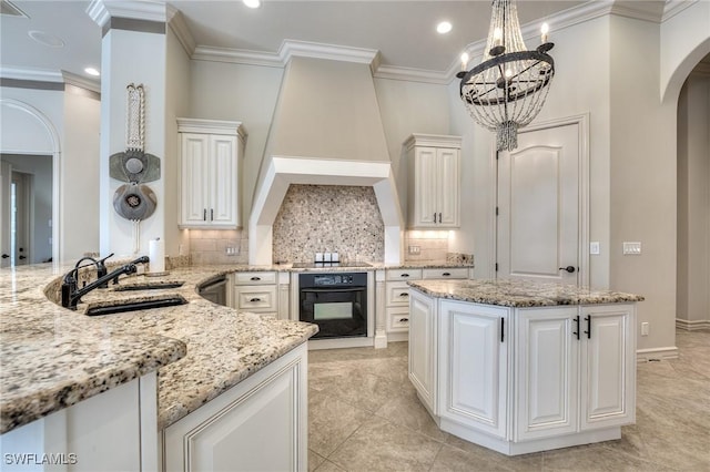 kitchen featuring sink, hanging light fixtures, light stone counters, black appliances, and white cabinets