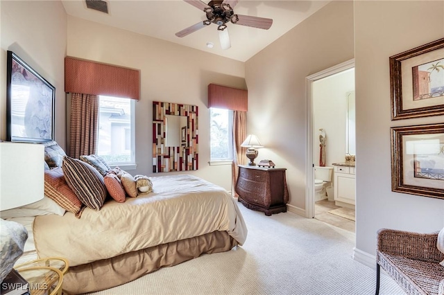 bedroom featuring connected bathroom, light colored carpet, and ceiling fan