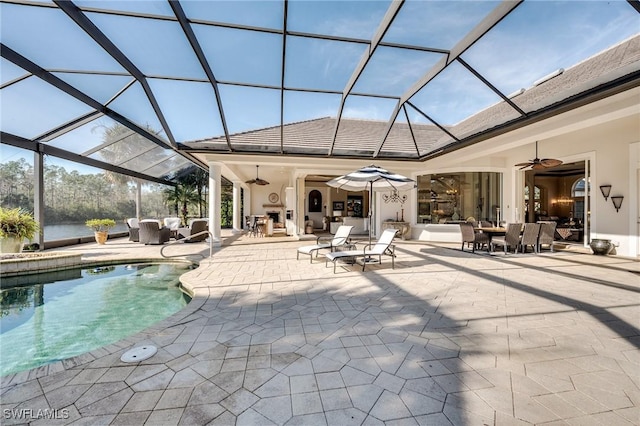 view of swimming pool with outdoor lounge area, ceiling fan, a lanai, and a patio area