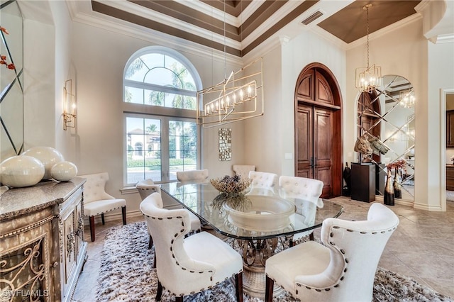 dining area featuring ornamental molding, a towering ceiling, an inviting chandelier, and a healthy amount of sunlight