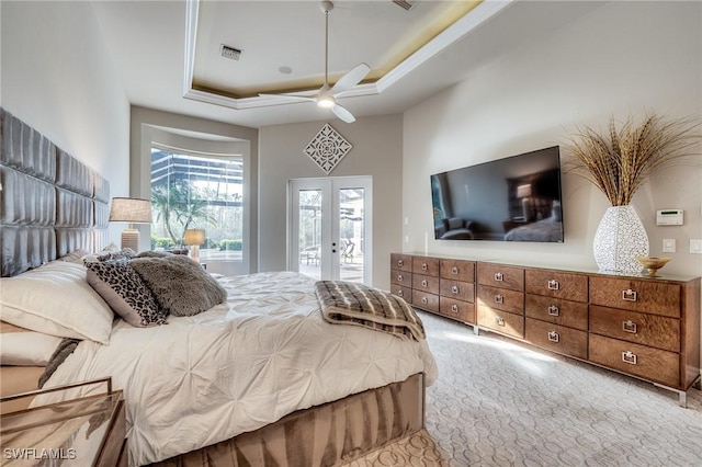 bedroom with french doors, light carpet, access to outside, a tray ceiling, and ceiling fan