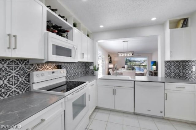 kitchen with white appliances, white cabinets, decorative light fixtures, tasteful backsplash, and sink