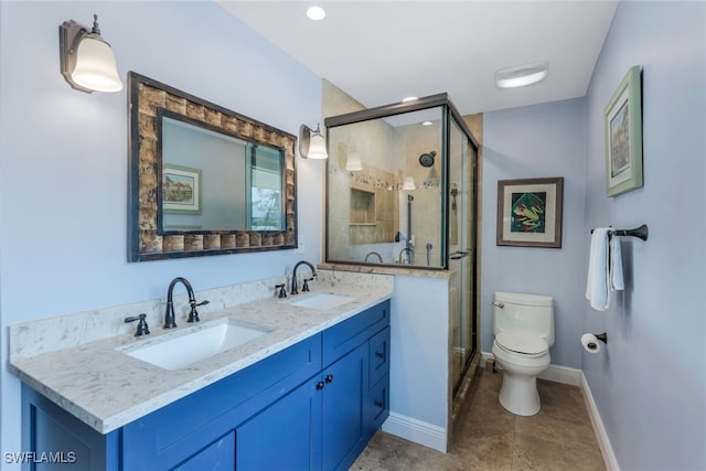 bathroom featuring vanity, a shower with door, and toilet