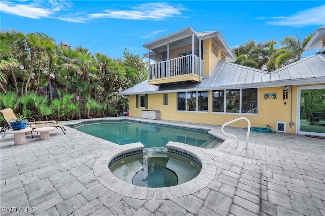 view of swimming pool with an in ground hot tub and a patio