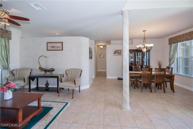 tiled dining room with decorative columns and ceiling fan with notable chandelier