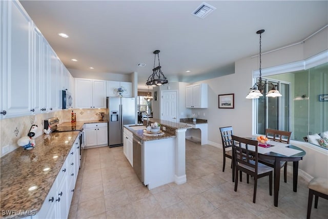 kitchen with white cabinetry, pendant lighting, stainless steel appliances, and a center island with sink