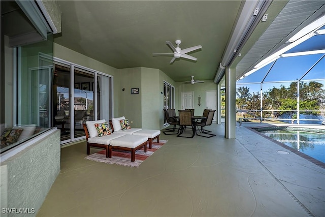 view of patio with ceiling fan and glass enclosure