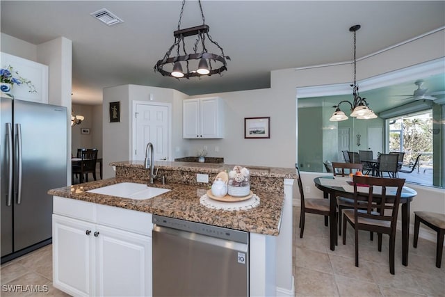 kitchen with sink, white cabinetry, a center island with sink, pendant lighting, and stainless steel appliances