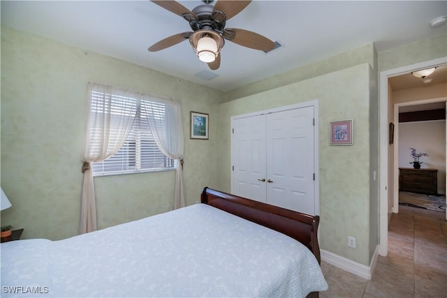 bedroom with light tile patterned floors, a closet, and ceiling fan