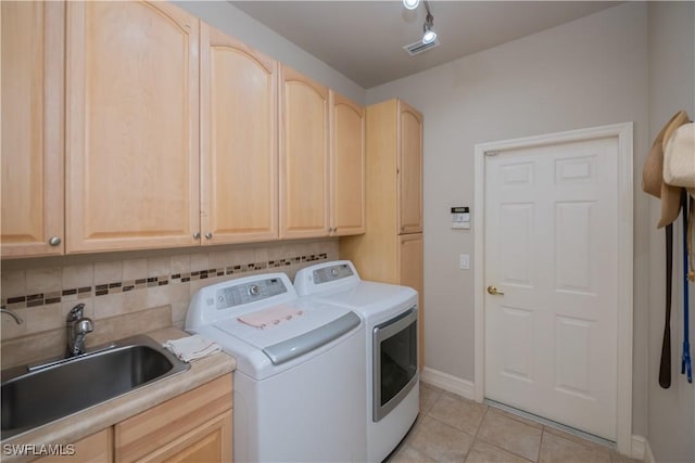 washroom with cabinets, separate washer and dryer, sink, and light tile patterned floors