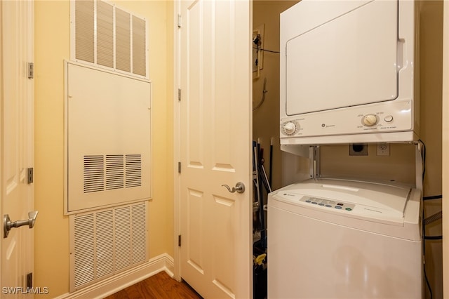 laundry room featuring dark hardwood / wood-style floors and stacked washing maching and dryer