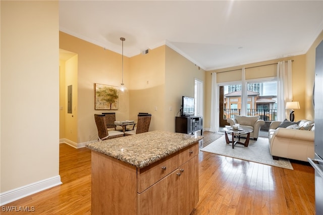 kitchen with light hardwood / wood-style floors, decorative light fixtures, ornamental molding, light stone countertops, and electric panel