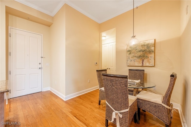 dining space featuring ornamental molding and hardwood / wood-style flooring