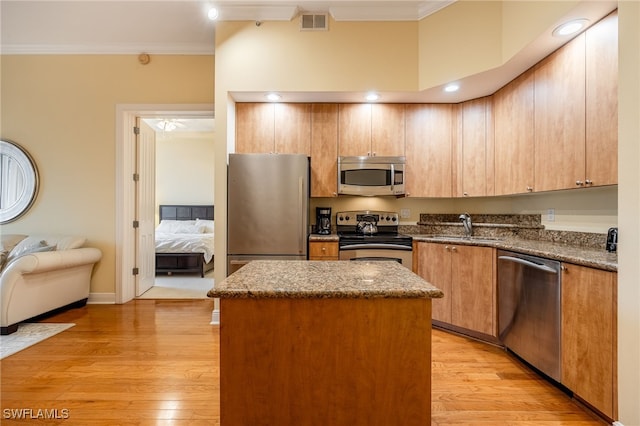 kitchen featuring sink, stainless steel appliances, crown molding, and a center island