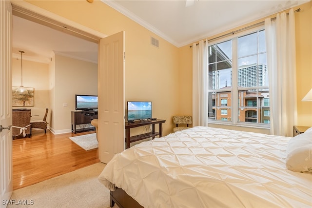 carpeted bedroom with ceiling fan and crown molding