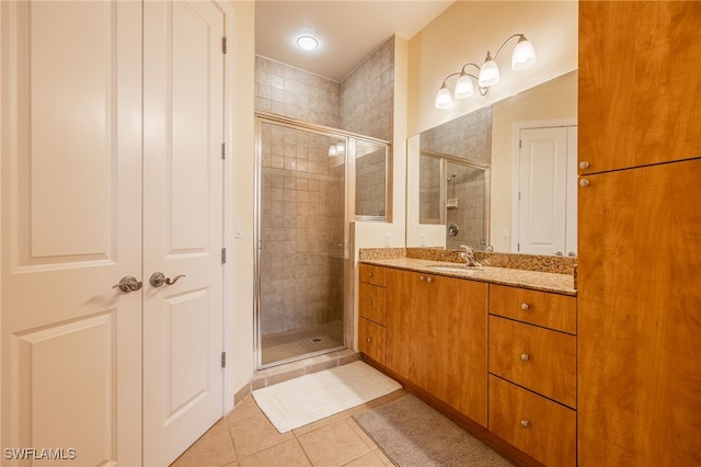 bathroom with tile patterned floors, a shower with door, and vanity