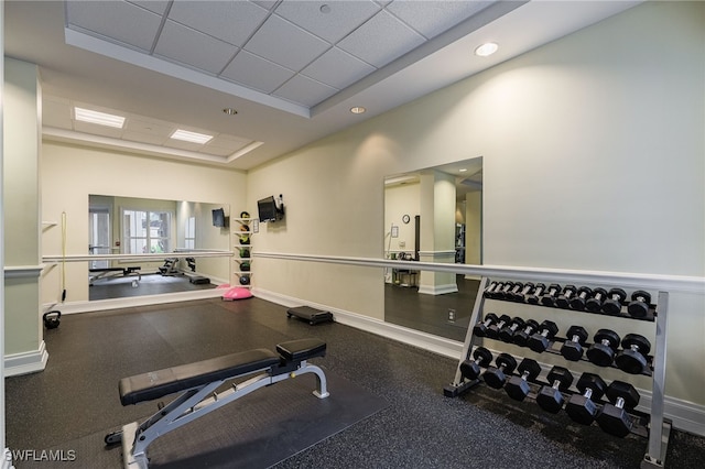 exercise area featuring a raised ceiling and a drop ceiling