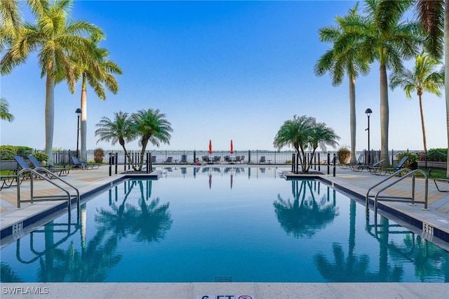 view of swimming pool featuring a water view and a patio