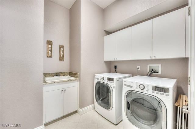 washroom with light tile patterned floors, independent washer and dryer, sink, and cabinets