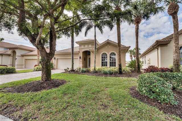 mediterranean / spanish-style house featuring a front lawn and a garage