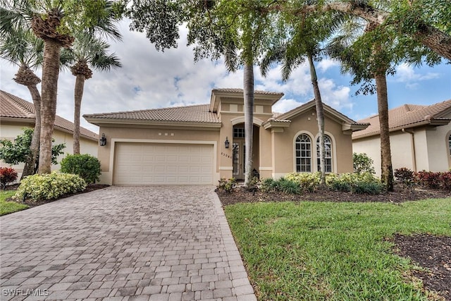 mediterranean / spanish home featuring a front lawn and a garage