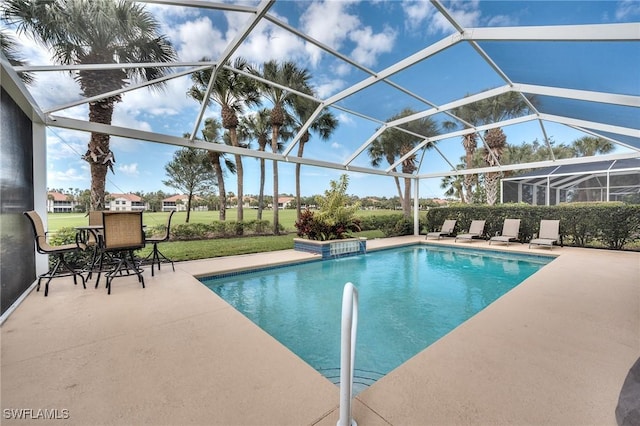 view of pool featuring glass enclosure, a yard, and a patio