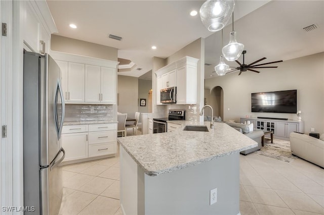 kitchen with pendant lighting, kitchen peninsula, sink, white cabinetry, and stainless steel appliances