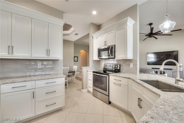 kitchen with pendant lighting, appliances with stainless steel finishes, white cabinetry, sink, and ceiling fan