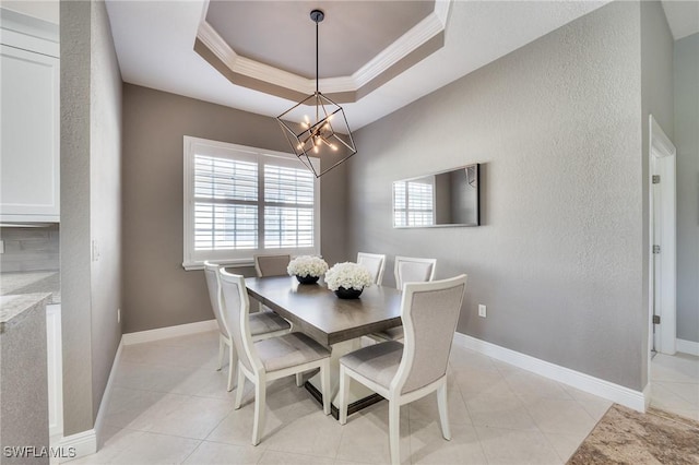 dining area featuring light tile patterned floors, ornamental molding, a tray ceiling, and a notable chandelier