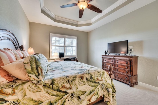 carpeted bedroom with ceiling fan, crown molding, and a tray ceiling