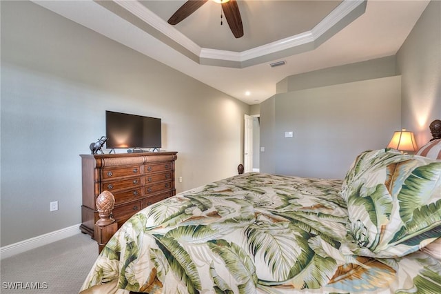 bedroom featuring ceiling fan, a raised ceiling, carpet floors, and ornamental molding