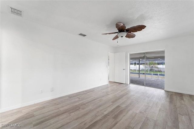 empty room with light hardwood / wood-style floors, a textured ceiling, and ceiling fan